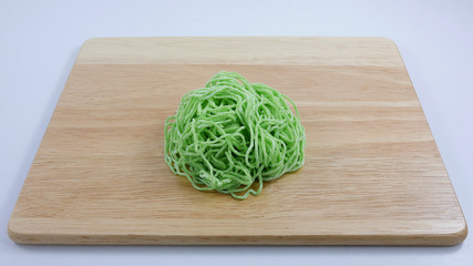The green egg noodle on wooden chopping board. (1)