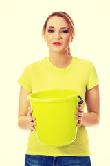 Young woman holding green bucket.
