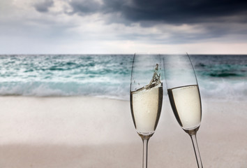 Champagne glasses on tropical beach at sunset - exotic New Year