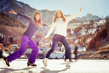 Group funny teenagers girls ice skating outdoor at ice rink