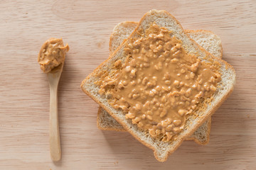 Peanut butter sandwich on wood background. Top view.