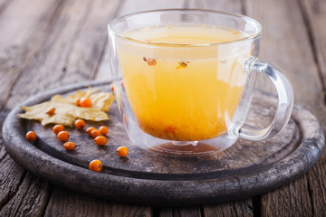 Sea buckthorn tea for health.Autumn naturpur on wooden background.