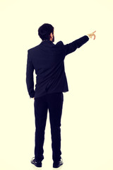Happy businessman points his finger up.