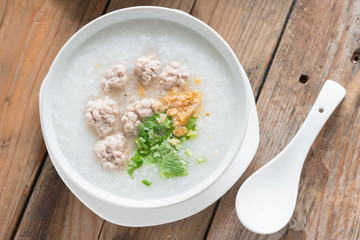 Asian congee with minced pork in white bowl. Top view.