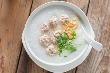 Asian congee with minced pork in white bowl. Top view.