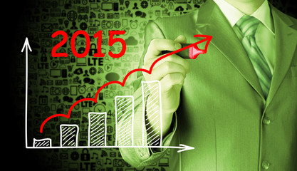 Fototapeta na wymiar business man drawing growth graph for year 2015