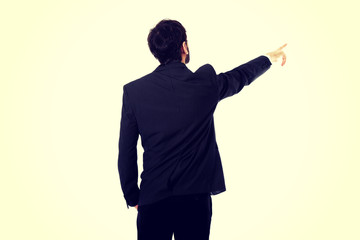 Happy businessman points his finger up.