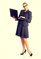 Businesswoman standing and holding a laptop