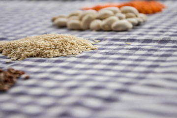 Sesame seeds, white beans, lentils and rice on the classic tablecloth