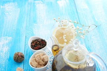 Ripe lemon, cinnamon and fruit drink in glass teapot on wooden background