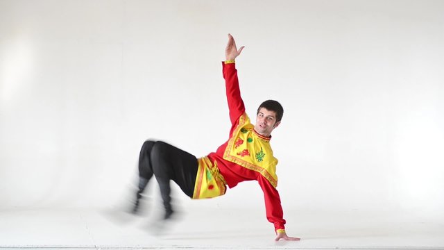 Young man wearing a folk costumes dancing on white in full length
