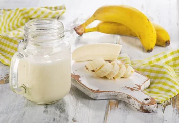 Papier Peint photo Milk-shake Fresh made Banana smoothie on wooden table.