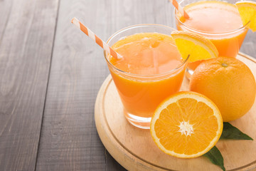 Obraz na płótnie Canvas Fresh orange juice and oranges on wooden table