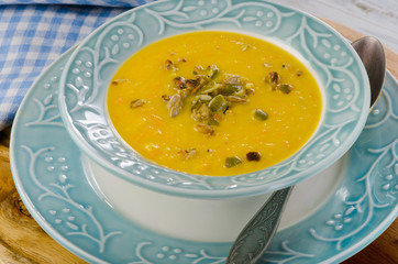 Bowl of pumpkin cream soup with pumpkin seeds.