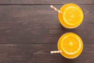 Fresh orange juice in glass on wooden background