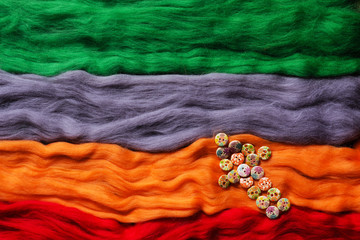 Multi-colored strands of wool felting and arrow made from buttons