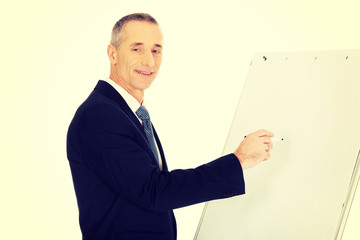 Male executive writing on a flipchart