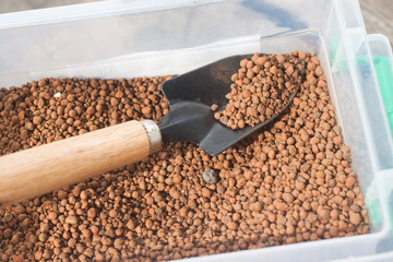 pumice pebbles in bucket and gardening tool
