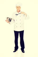 Chef holding stainless steel pot and spoon