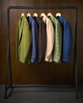 Jackets Hanging On A Rack With A Wooden Background