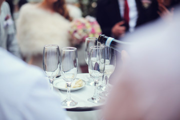 Waiter pouring champagne in glasses