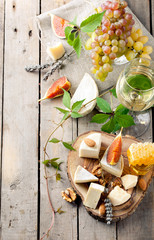 Grape, cheese, figs and honey with a glasses wine. 