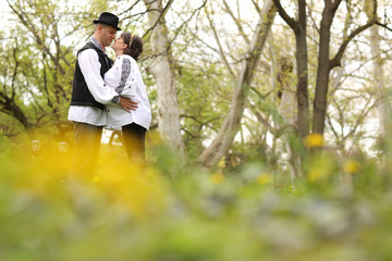 Happy and young pregnant couple embracing in nature