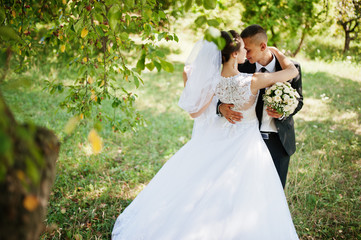 young happy wedding couple on the green park
