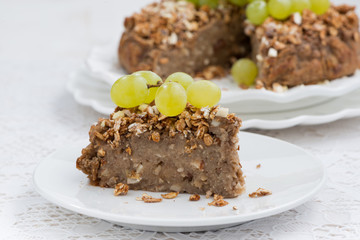 piece of delicious nut pie with grapes on plate