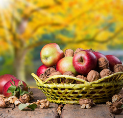 Apples on wooden table over autumn bokeh background