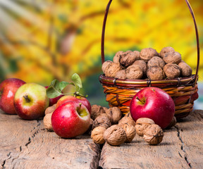 Apples on wooden table over autumn bokeh background