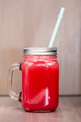 Watermelon smoothie in a mason jar with tube