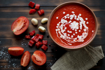 Gazpacho soup on a dark rustic wooden background, above view