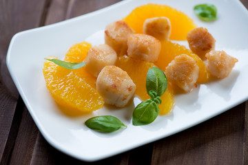 Roasted scallops with orange fillet, selective focus, closeup
