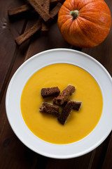 Close-up of pumpkin soup with croutons, view from above