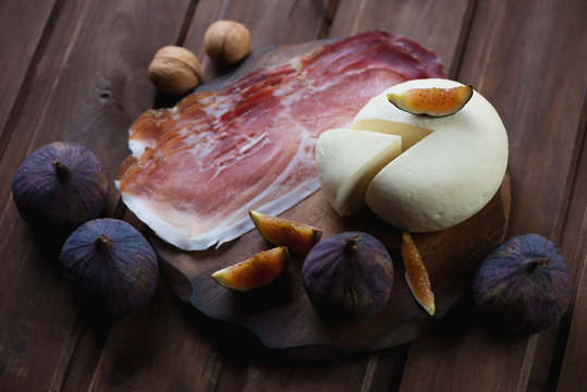 Sliced cheese with ham and fresh fig fruits, selective focus