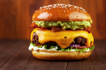 Guacamole beef burger with melted cheese and bacon on wooden background - obrazy, fototapety, plakaty