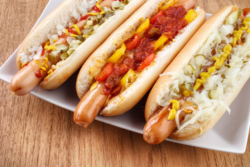 Three hot dogs on dish closeup