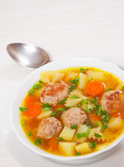 Soup with meatballs, farfalle pasta and vegetables