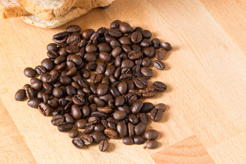 coffee beans and bread on wooden table