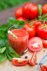 Fresh tomato juice on wooden background