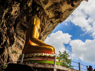golden buddhist  in wild cave