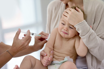 Baby girl at doctor's office receiving vaccine injection