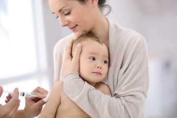 Baby girl at doctor's office receiving vaccine injection