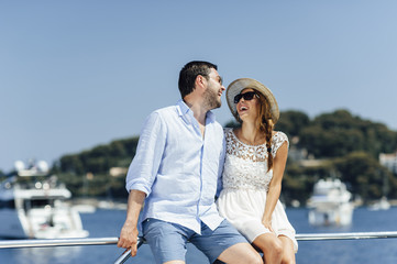 Attractive couple on a yacht enjoy bright sunny day on vacation