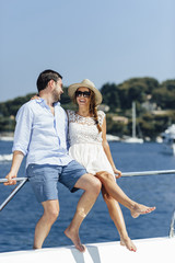 Attractive couple on a yacht enjoy bright sunny day on vacation