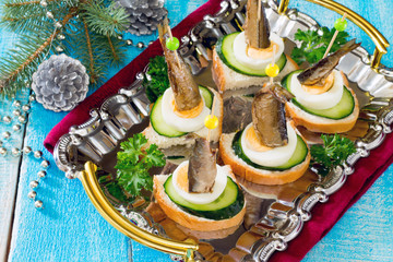 Canapé with fresh cucumber, egg and sprats