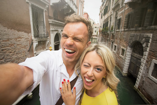 Cheerful couple taking funny selfie picture