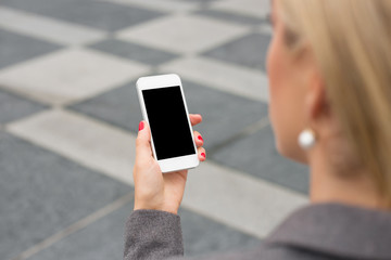 Business woman looking at smartphone in hand