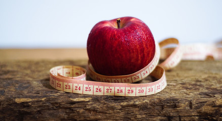 Healthy And Beauty Concept.Apple With Measuring Tape On Wood Table.